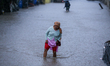 A Nepali woman wades through the floodwater in Kathmandu, Nepal, on September 27, 2024. Th...