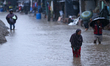 A Nepali woman wades through the floodwater in Kathmandu, Nepal, on September 27, 2024. Th...