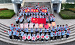 Primary school students pose for a photo with the national flag to celebrate the 75th anni...
