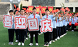 Primary school students pose for a photo with the national flag to celebrate the 75th anni...