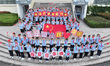 Primary school students pose for a photo with the national flag to celebrate the 75th anni...