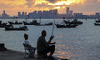 Tourists fish on the beach of Gujia Island in the West Coast New Area of Qingdao, Shandong...