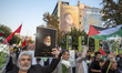 An Iranian protester carries a portrait of Lebanon's Hezbollah Secretary General, Hassan N...