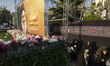 Veiled Iranian protesters sit next to a giant banner depicting a portrait of Lebanon's Hez...