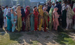 Voters queue to cast their ballots at a polling station during the third and final phase o...