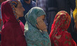 Women voters queue to cast their ballots at a polling station during the third and final p...
