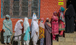 Women voters queue to cast their ballots at a polling station during the third and final p...