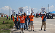 Dockworkers and their supporters hold signs during a strike outside the Bayport Container...
