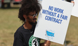Dockworkers and their supporters hold signs during a strike outside the Bayport Container...