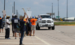 A passing driver holds up his fist in solidarity with a group of striking dockworkers outs...