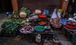 An elderly woman sells vegetables and waits for customers on a roadside in Baramulla, Jamm...