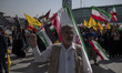 Iranian people wave Iranian flags and Lebanon's Hezbollah flags during a gathering marking...