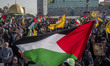 An Iranian man (not pictured) waves a Palestinian flag as others hold portraits of Lebanon...