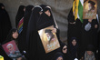 Veiled Iranian women hold portraits of Lebanon's Hezbollah Secretary General Hassan Nasral...