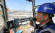 In Wuxi, China, on October 3, 2024, a driver of a tower crane uses a walkie-talkie in his...