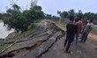 People stand near the erosion caused by the Kopilli River on a section of the PWD road nea...