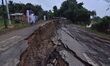 People stand near the erosion caused by the Kopilli River on a section of the PWD road nea...