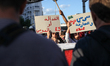 Demonstrators raise a placard that reads in Arabic, ''justice or chaos,'' during a demonst...