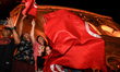 Kais Saied supporters wave the national flags of Tunisia as they celebrate after unofficia...