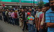 People wait in queue to enter Bakshi Stadium during the Legends League Cricket match betwe...