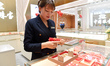 A staff member arranges gold ornaments at a gold shop in Renhuai, China, on October 11, 20...