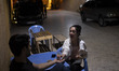 Iranian youths sit at an outdoor cafe in a garden in Shiraz, Iran, on October 7, 2024, whi...