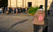 A man looks on as people gather outside a church after a wedding ceremony in Warsaw, Polan...