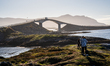 Tourists walk along a scenic pathway near a bridge on the Atlantic Ocean Road in Norway, o...