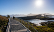 Tourists walk along a scenic pathway near a bridge on the Atlantic Ocean Road in Norway, o...