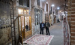 An Iranian trader and a shopper look at an Iranian handwoven carpet at a carpet bazaar in...