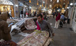 An Iranian worker carries a Persian handwoven carpet by cart at the Mozaffarieh Carpet Baz...