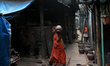 A woman carries an earthen pot at Kumbharwada potter's colony of Dharavi slum in preparati...