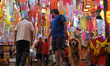 People with a pet dog shop for lanterns at a market ahead of the Hindu festival of Diwali...