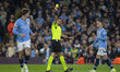 Referee Maurizio Mariani shows a yellow card to John Stones #5 of Manchester City F.C. dur...