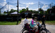 People on a motorcycle pass by an army base in Pattani. Special Forces, the Black Army, an...