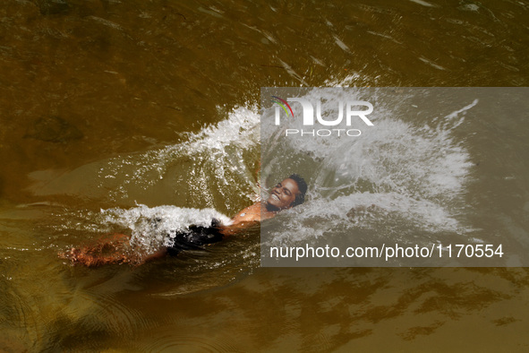 A village boy jumps into the water of an irrigation canal to beat the heat in today’s hot afternoon outskirts of the eastern Indian city Bhu...