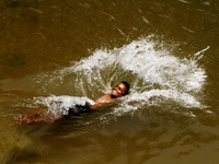 A village boy jumps into the water of an irrigation canal to beat the heat in today’s hot afternoon outskirts of the eastern Indian city Bhu...