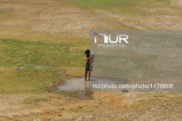 A village boy baths in the remaining water of a dried pond to beat the heat in today’s hot afternoon outskirts of the eastern Indian city Bh...