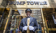 A welcoming butler posing in front of Trump Tower entrance. Trump Tower building with the...