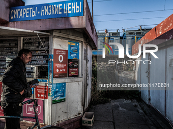 A man buys cigarettes before taking the train in Slavutich, Ukraine,  for the workers in the Chernobyl nuclear plant crossing Belarus, on Au...