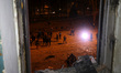 A shattered window frames people in the street outside the 1930s Derzhprom building, which...