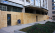 Workers cover storefront entrances with plywood near the White House in Washington, D.C. o...