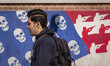 A young Iranian man walks past an anti-U.S. mural on a wall of the former U.S. embassy in...
