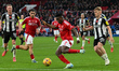 Taiwo Awoniyi of Nottingham Forest is under pressure from Lewis Hall of Newcastle United d...