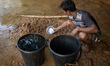 A tribal man collects water from the reservoir, locally known as ''Jhiri,'' in Durgapur, N...