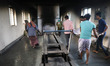 Tumpa Das, age 29, prepares a dead body for cremation in a furnace inside a crematorium in...