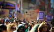 A woman holds a placard reading 'We don't want anymore to continue to count our dead'. Wom...