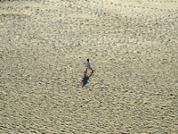 An indian man walks on sand,the dried and shrinked River bed of Ganges river,during a hot day in Allahabad on April 28,2016.The drought has...