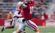 Wisconsin Badgers quarterback Braedyn Locke #18 rolls out of the pocket for a pass against...