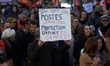 A protester holds a placard reading 'Jobs cut, child welfare service in danger'. Between 8...